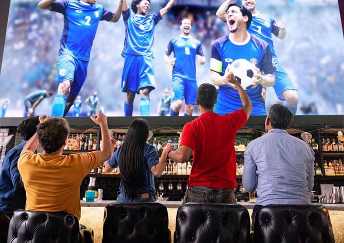 バーでチームのゴールを祝うサッカーファンたち