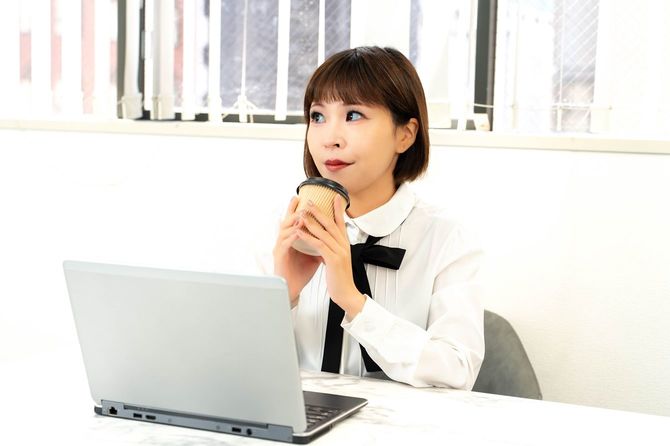 コーヒーを飲みながら休憩する女性