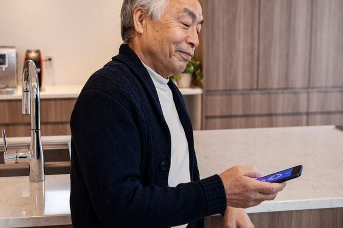 スマートフォンを使用してスマート家電からライトをつける男性