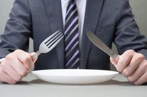 ナイフとフォークを持っている日本人ビジネスマンの手