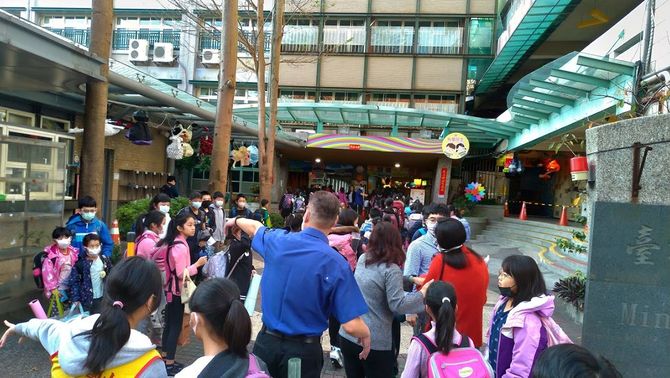 2週間後ろ倒しされた2月25日の開校初日、台北市内の小学校の入口付近で検温開始を待つ児童。