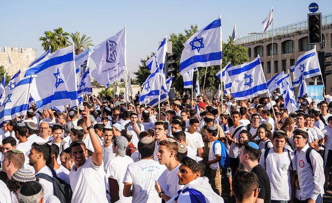 イスラエルの国旗を持ってエルサレムの日を祝う人々