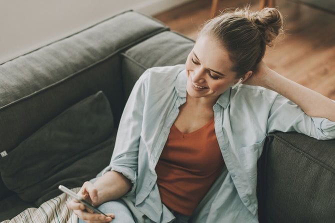 ソファに座ってスマホを使用する女性