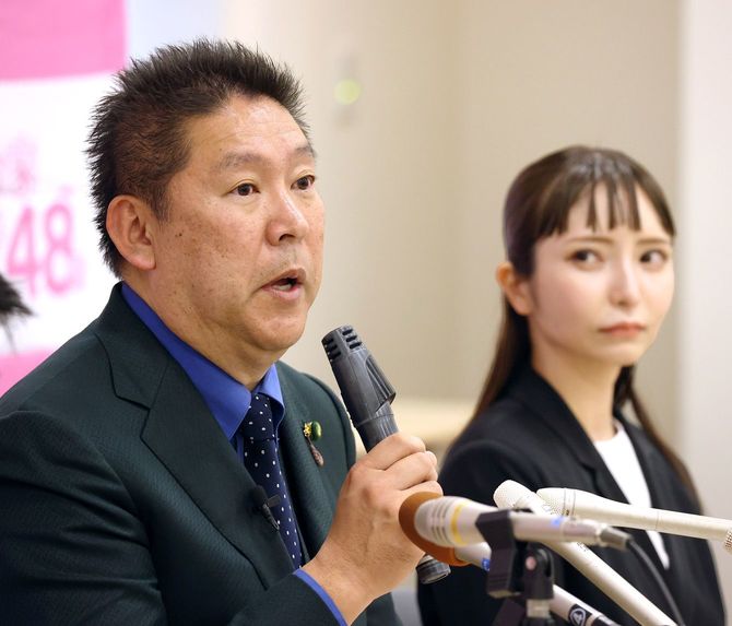 辞任の意向を表明したNHK党の立花孝志党首。右は新党首の大津綾香氏＝2023年3月8日、東京・永田町の参院議員会館