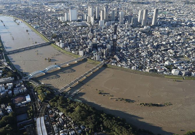 台風19号の影響で水位が上がった多摩川の丸子橋(手前から2本目)付近=2019年10月13日、手前は東京都大田区、奥は川崎市中原区(共同通信社ヘリから)