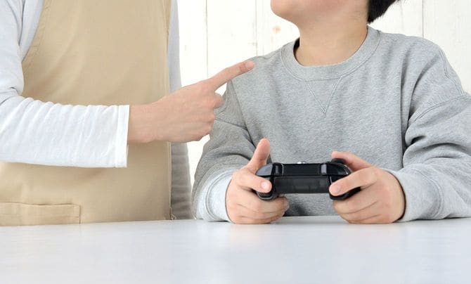 ゲームをしている子どもを叱る母親