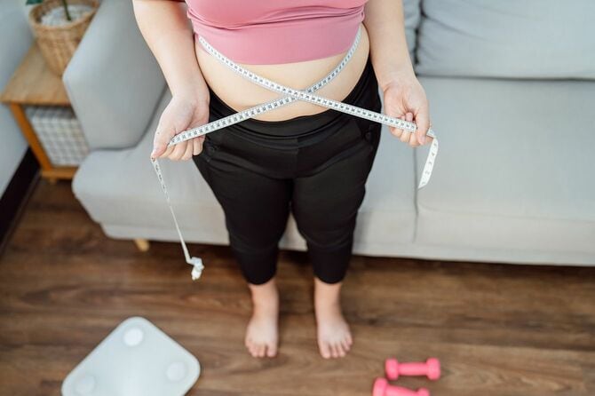 女性がウエストを測定