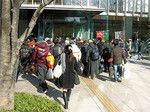 区役所に集団で生活保護申請に訪れた人々とボランティア。