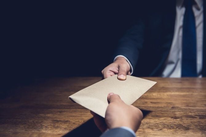 暗闇の中で賄賂を与える男