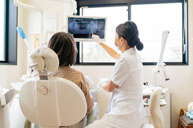 患者にX線について説明する女性歯科医師