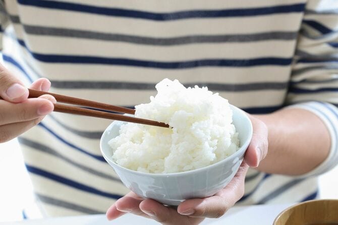茶碗の白米を食べる人