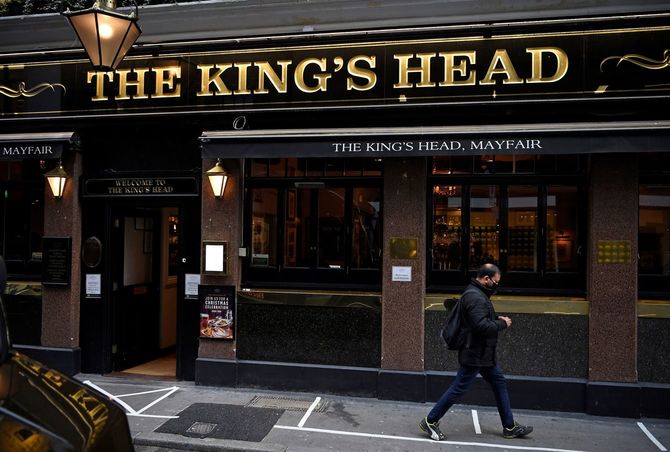 イギリスのパブ「The Kings Head」の前を通り過ぎる市民（2020年11月3日、ロンドン）