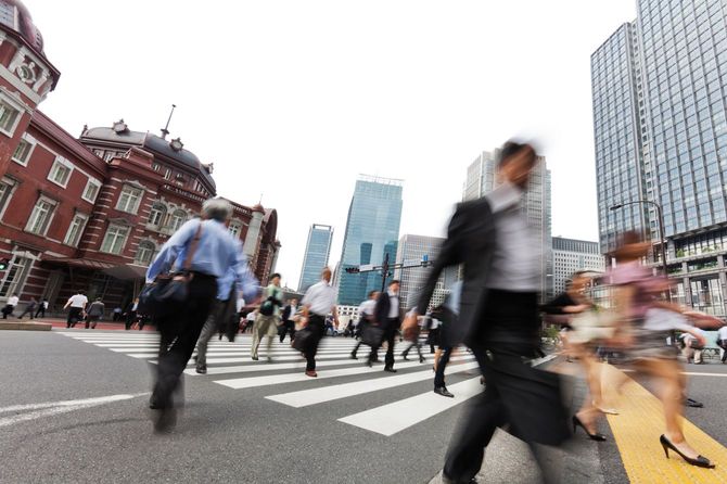 東京駅前の交差点を渡る人々