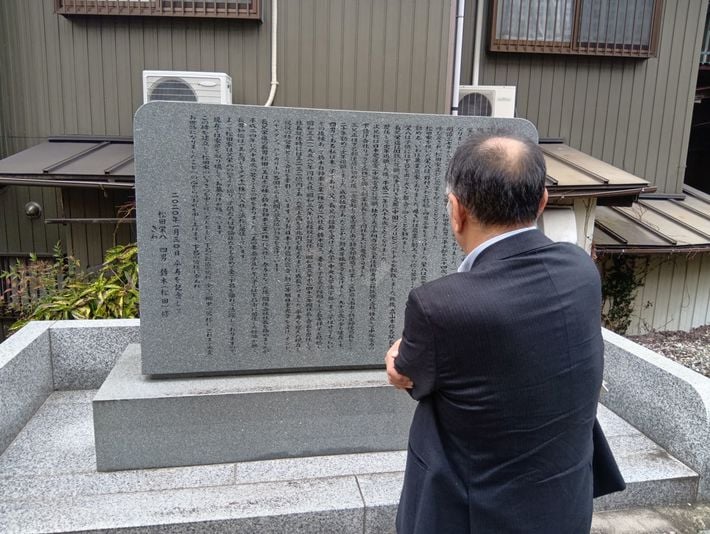 鈴木修の生まれた岐阜県下呂市に建てられた松田家の石碑を取材する著者。