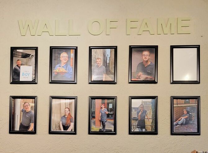 壁にはスタッフの写真が並ぶ