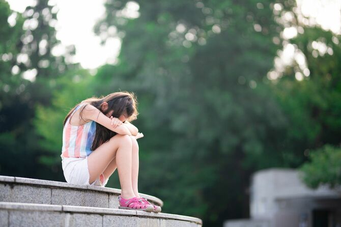 公園の階段に座り、泣いている女の子