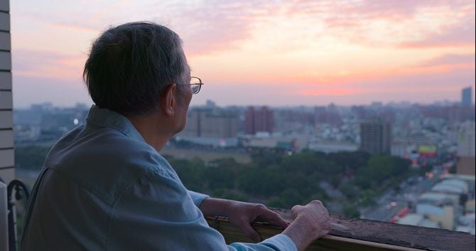 家から外を見ている孤独なアジアの老人のクローズアップ