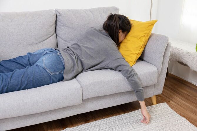ソファにうつ伏せになる燃え尽き症候群の女性