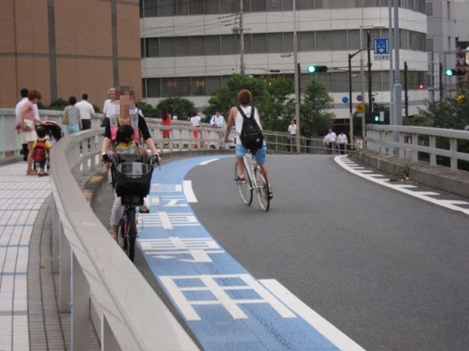逆走する子乗せ自転車を若者のピストが避けている