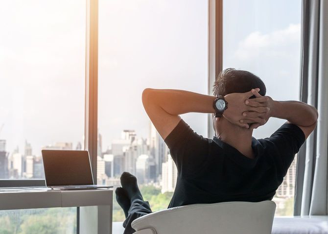 椅子にもたれかかり窓の外を眺める男性