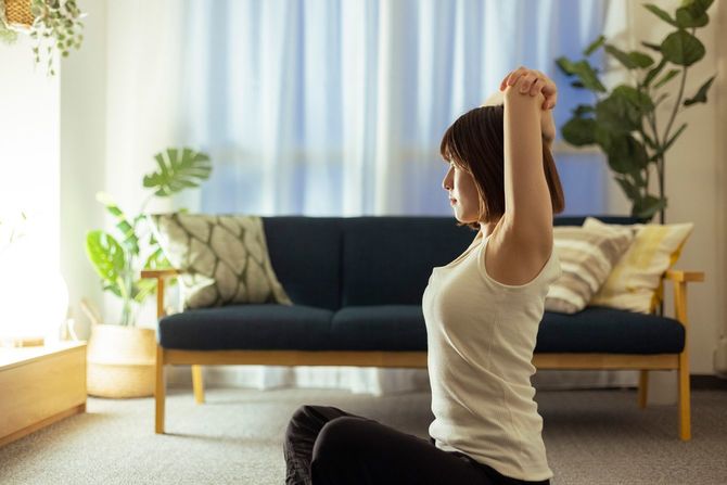 リビングルームでストレッチをする女性