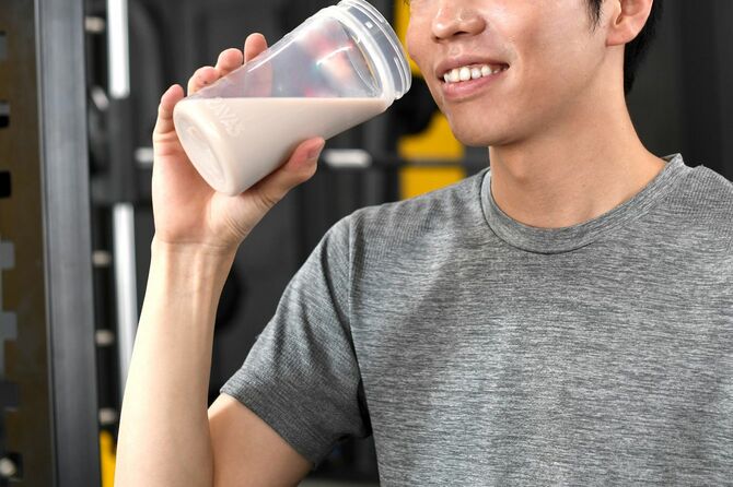 ジムでプロテインドドリンクを飲む男性