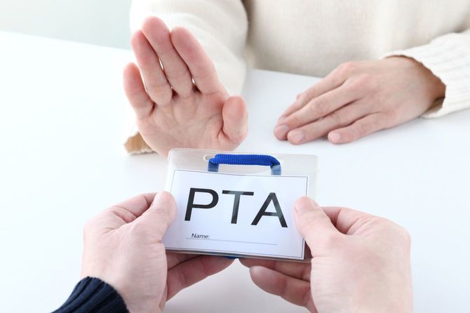 PTAネームプレートの受け取りを拒否する女性の手元
