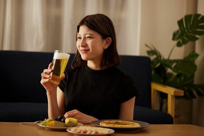 家で一人でアルコールを楽しむ若い日本人女性