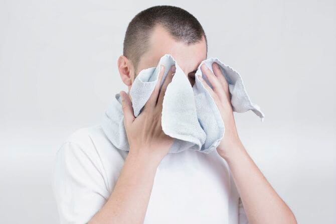 タオルで顔をふく男性