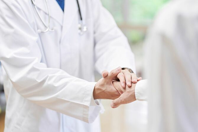 患者と握手を担当する医師