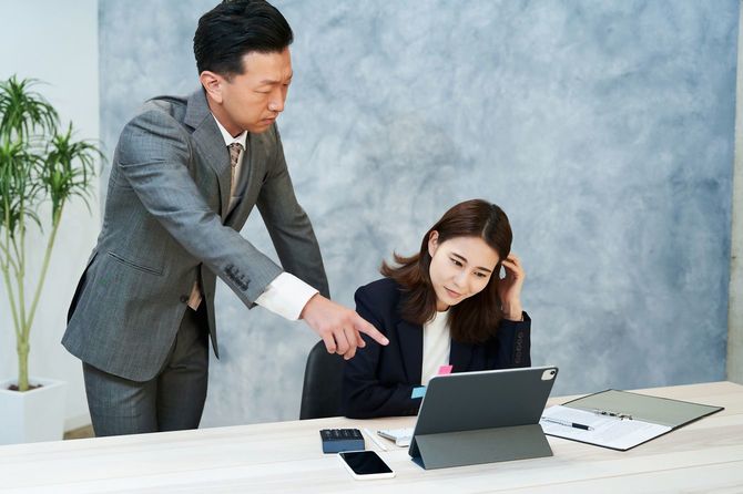 部下の女性社員を指導する男性社員