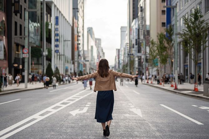 人通りのまばらな銀座の街を両手を広げて自由に歩く女性