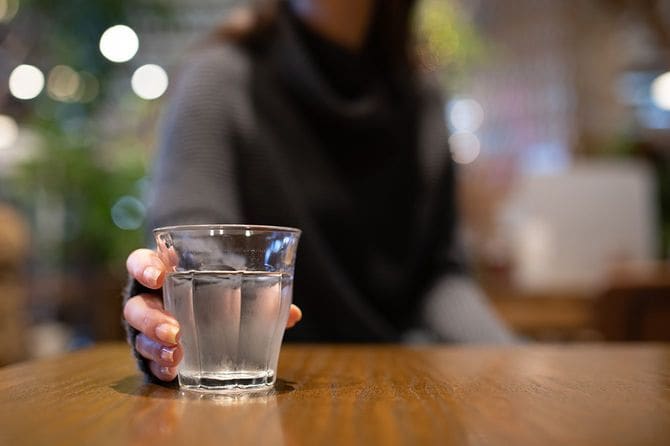 テーブルに水を持つ女性