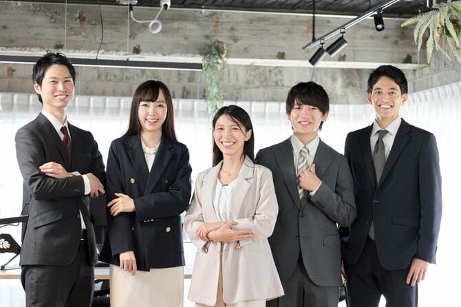 オフィスに笑顔で並ぶビジネスパーソンたち
