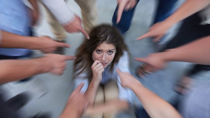 同僚から隠れようとする若い女性