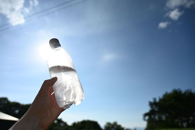 ペットボトルの水を持つ手