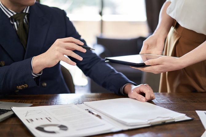 タブレット端末を差し出す女性に支持を出す男性