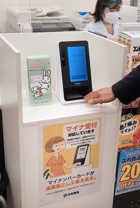 マイナンバーカードを健康保険証として利用できるようにする「オンライン資格確認システム」の試行運用が始まり、薬局の窓口に設置された顔認証付きカードリーダー＝2021年3月4日、東京都千代田区