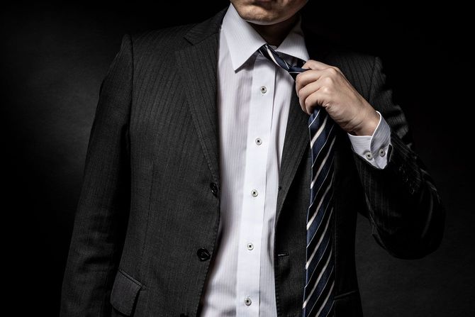 ネクタイを緩めるスーツ姿の男性