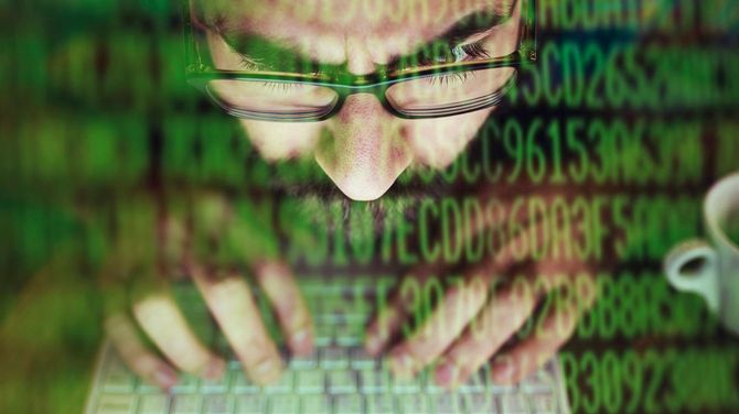 ハッカーがノートパソコンで情報を盗んでいる