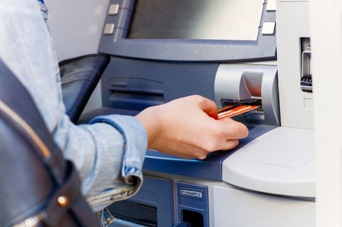 ATMにカードを差し込む人の手元