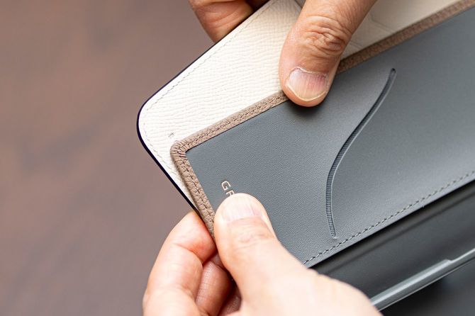 角に丸みのある一般的な手帳型ケース（奥）と異なり、GRAMASのケース（手前）は直角になっている。GRAMASのケースは、革の端を折ってからステッチを施す「ヘリ返し技法」で仕上げることにより、耐久性を高めている