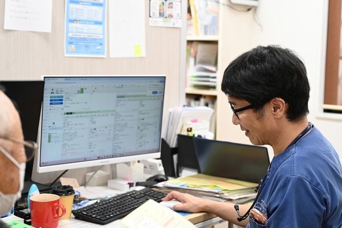 水野クリニックの診察室で患者と話をする水野さん