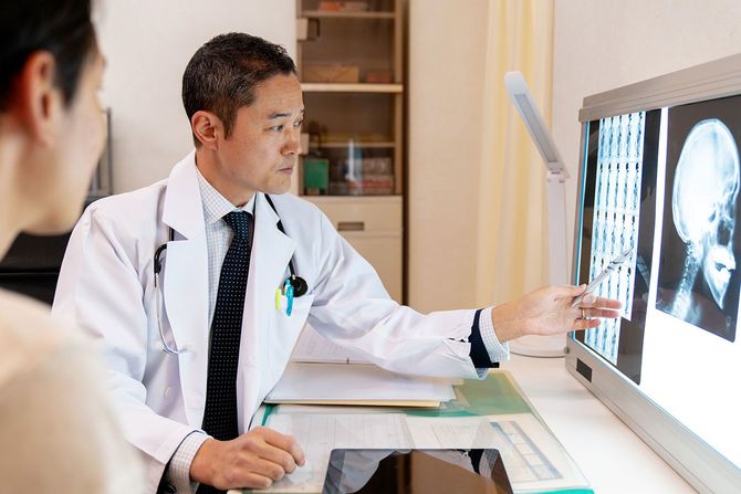 レントゲン画像を見せながら、患者に説明をする医師
