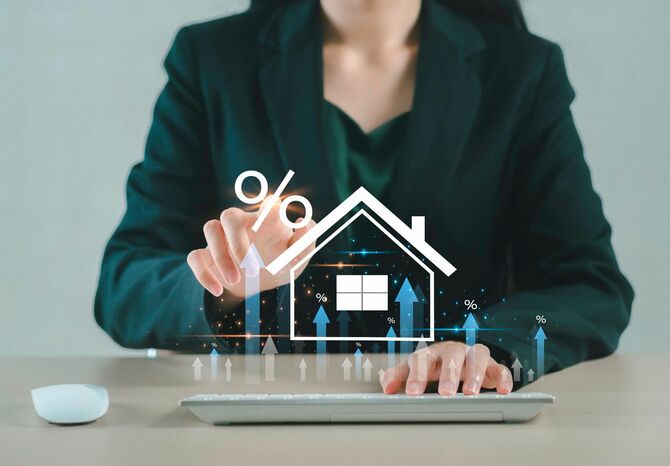 家とパーセンテージアイコンに触れる女性