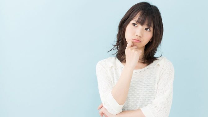 首をかしげる若い女性