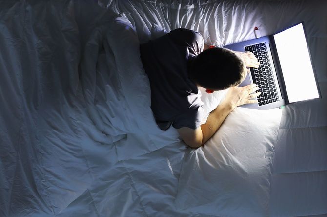 ベッドに寝転んでノートパソコンを開きインターネットをしている