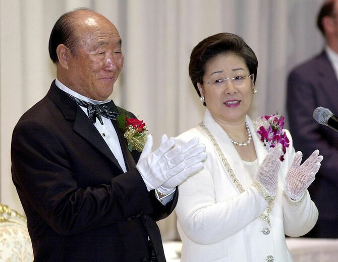 2001年5月27日、ニューヨークのヒルトンホテルで行われた集団結婚式で拍手する文鮮明氏（左）と妻の韓鶴子氏（右）。韓国出身の救世主と自称し、物議を醸す統一教会と自動車から寿司に至るビジネス帝国を設立した文氏が、2012年9月3日、92歳で死去。