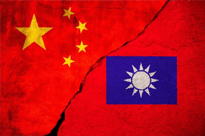 赤い壁に描かれた中国と台湾の国旗の間に大きな亀裂