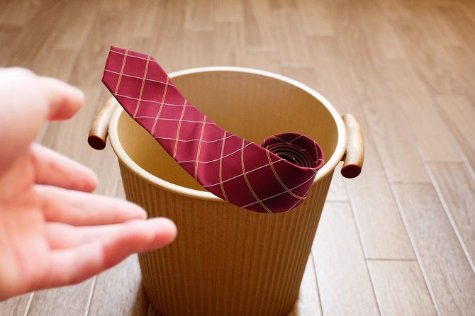 赤いネクタイをゴミ箱に投げ込む